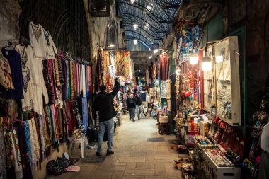 Kudüs, İsrail, 13 Aralık 2025 Kudüs 'ün Hristiyan Mahallesi' ndeki dar sokaklar ve atmosferik ışık oyunları yerel satıcılar tarafından sergilenen çeşitli ürünlere bir göz atma olanağı sağlıyor..