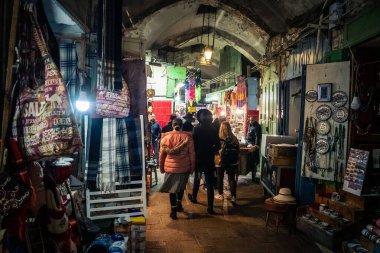 Kudüs, İsrail, 13 Aralık 2025 Kudüs 'ün Hristiyan Mahallesi' ndeki dar sokaklar ve atmosferik ışık oyunları yerel satıcılar tarafından sergilenen çeşitli ürünlere bir göz atma olanağı sağlıyor..