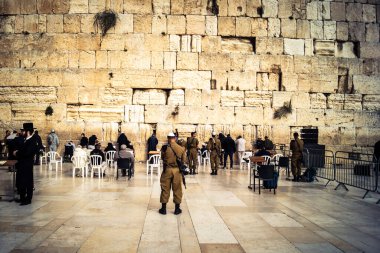 Kudüs, İsrail, 14 Aralık 2025 İsrail Savunma Kuvvetleri (IDF) askerleri, eski Kudüs şehrindeki Batı Duvarı (Kotel) önünde üniformalı ve silahlı dua ediyorlar..