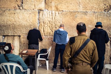 Kudüs, İsrail, 14 Aralık 2025 İsrail Savunma Kuvvetleri (IDF) askerleri, eski Kudüs şehrindeki Batı Duvarı (Kotel) önünde üniformalı ve silahlı dua ediyorlar..