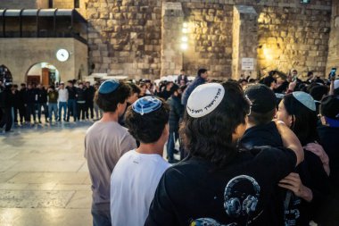 Kudüs, İsrail, 14 Aralık 2025 Yahudi gençler Eski Kudüs 'teki Hanuka kutlamaları sırasında Batı Duvarı (Kotel) önünde sevinçle omuz omuza ve dans ediyorlar..