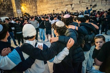 Kudüs, İsrail, 14 Aralık 2025 Yahudi gençler Eski Kudüs 'teki Hanuka kutlamaları sırasında Batı Duvarı (Kotel) önünde sevinçle omuz omuza ve dans ediyorlar..