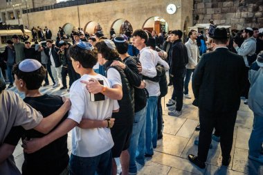 Kudüs, İsrail, 14 Aralık 2025 Yahudi gençler Eski Kudüs 'teki Hanuka kutlamaları sırasında Batı Duvarı (Kotel) önünde sevinçle omuz omuza ve dans ediyorlar..