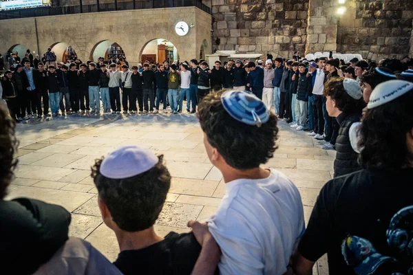 Kudüs, İsrail, 14 Aralık 2025 Yahudi gençler Eski Kudüs 'teki Hanuka kutlamaları sırasında Batı Duvarı (Kotel) önünde sevinçle omuz omuza ve dans ediyorlar..