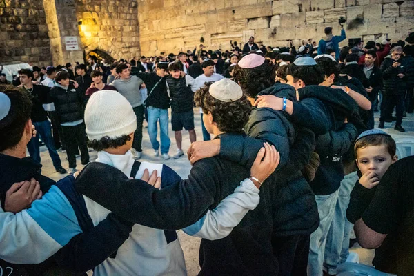 Kudüs, İsrail, 14 Aralık 2025 Yahudi gençler Eski Kudüs 'teki Hanuka kutlamaları sırasında Batı Duvarı (Kotel) önünde sevinçle omuz omuza ve dans ediyorlar..