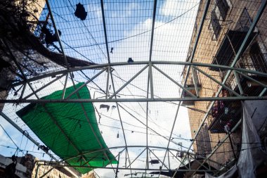 Hebron, Batı Şeria, 17 Aralık 2025 Eski Şehirdeki Filistin sokaklarına kurulmuş koruyucu metal ağlar İsrailli yerleşimcilerin yukarıdaki evlerden attığı taş ve enkazı yakalamak için.