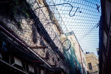 Hebron, Batı Şeria, 17 Aralık 2025 Eski Şehirdeki Filistin sokaklarına kurulmuş koruyucu metal ağlar İsrailli yerleşimcilerin yukarıdaki evlerden attığı taş ve enkazı yakalamak için.