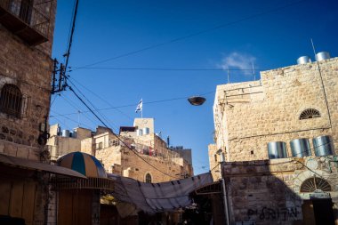 Hebron, Batı Şeria, 17 Aralık 2025 İsrail yerleşim birimleri ve Filistin sokaklarına bakan yerleşim birimleri, bölgesel çatışmanın yakın çevresini ve dikey doğasını vurguluyor..