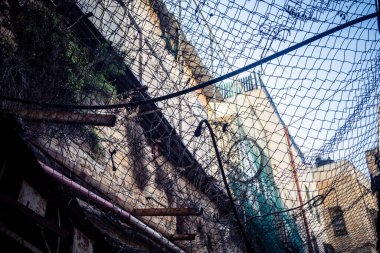 Hebron, Batı Şeria, 17 Aralık 2025 Eski Şehirdeki Filistin sokaklarına kurulmuş koruyucu metal ağlar İsrailli yerleşimcilerin yukarıdaki evlerden attığı taş ve enkazı yakalamak için.