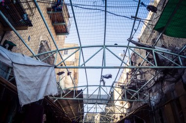 Hebron, Batı Şeria, 17 Aralık 2025 Eski Şehirdeki Filistin sokaklarına kurulmuş koruyucu metal ağlar İsrailli yerleşimcilerin yukarıdaki evlerden attığı taş ve enkazı yakalamak için.