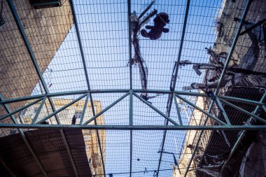 Hebron, Batı Şeria, 17 Aralık 2025 Eski Şehirdeki Filistin sokaklarına kurulmuş koruyucu metal ağlar İsrailli yerleşimcilerin yukarıdaki evlerden attığı taş ve enkazı yakalamak için.