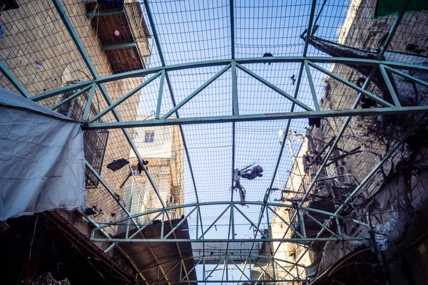 Hebron, Batı Şeria, 17 Aralık 2025 Eski Şehirdeki Filistin sokaklarına kurulmuş koruyucu metal ağlar İsrailli yerleşimcilerin yukarıdaki evlerden attığı taş ve enkazı yakalamak için.