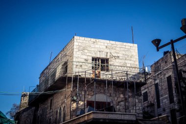 Hebron, Batı Şeria, 17 Aralık 2025 Vibrant sokak yaşamı ve Filistin 'deki El Halil' in merkezindeki işlek pazarlar. Sarı taksiler ve kalabalık kalabalık kalabalık işlek caddelerde geziniyor..