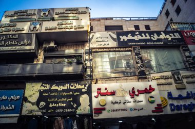 Hebron, Batı Şeria, 17 Aralık 2025 Vibrant sokak yaşamı ve Filistin 'deki El Halil' in merkezindeki işlek pazarlar. Sarı taksiler ve kalabalık kalabalık kalabalık işlek caddelerde geziniyor..