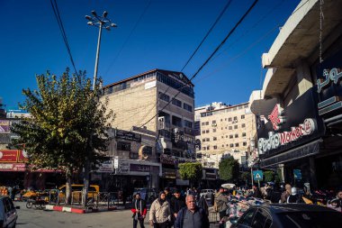 Hebron, Batı Şeria, 17 Aralık 2025 Vibrant sokak yaşamı ve Filistin 'deki El Halil' in merkezindeki işlek pazarlar. Sarı taksiler ve kalabalık kalabalık kalabalık işlek caddelerde geziniyor..