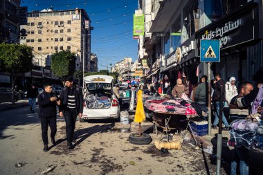 Hebron, Batı Şeria, 17 Aralık 2025 Vibrant sokak yaşamı ve Filistin 'deki El Halil' in merkezindeki işlek pazarlar. Sarı taksiler ve kalabalık kalabalık kalabalık işlek caddelerde geziniyor..