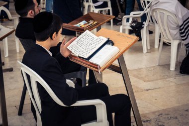 Kudüs, İsrail, 14 Aralık 2025 Yahudi çocuk Eski Kudüs şehrindeki Hanuka kutlamalarının ilk gününde Batı Duvarı 'nın (Kotel) erkekler bölümünde namaz kılıyor..