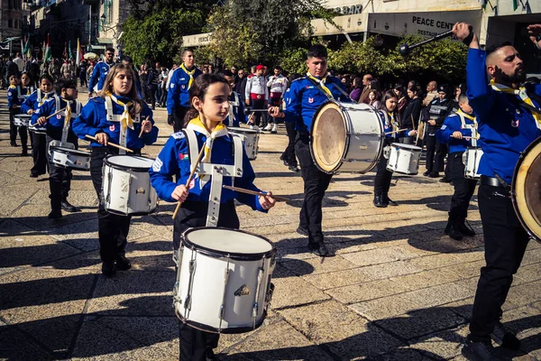 Beytüllahim, Batı Şeria, 24 Aralık 2025 Filistinli izci bandosu Noel geçit töreni sırasında sahne alır. Geleneksel üniforma giymiş müzisyenler tarihi caddelerde geçit törenine önderlik ediyorlar.
