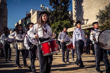 Beytüllahim, Batı Şeria, 24 Aralık 2025 Filistinli izci bandosu Noel geçit töreni sırasında sahne alır. Geleneksel üniforma giymiş müzisyenler tarihi caddelerde geçit törenine önderlik ediyorlar.