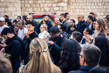 25 Aralık 2025 'te Beytüllahim, Batı Şeria' da büyük Hıristiyan cemaatleri İsa 'ya tapanlar, rahipler tarafından verilen bir sokak konserinde şarkı söyleyip kutluyorlar..