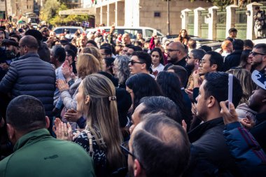 25 Aralık 2025 'te Beytüllahim, Batı Şeria' da büyük Hıristiyan cemaatleri İsa 'ya tapanlar, rahipler tarafından verilen bir sokak konserinde şarkı söyleyip kutluyorlar..