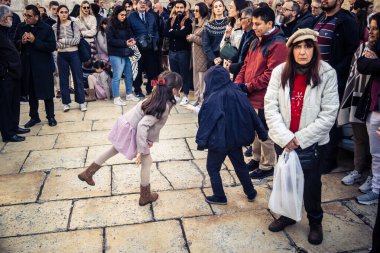 25 Aralık 2025 'te Beytüllahim, Batı Şeria' da büyük Hıristiyan cemaatleri İsa 'ya tapanlar, rahipler tarafından verilen bir sokak konserinde şarkı söyleyip kutluyorlar..