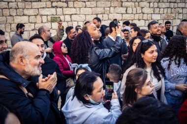 25 Aralık 2025 'te Beytüllahim, Batı Şeria' da büyük Hıristiyan cemaatleri İsa 'ya tapanlar, rahipler tarafından verilen bir sokak konserinde şarkı söyleyip kutluyorlar..