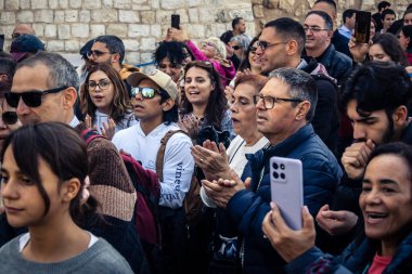 Beytüllahim, Batı Şeria, 25 Aralık 2025. İsa 'ya tapanların yakın çekimleri, İsa' nın Doğumu Kilisesi 'nin önünde rahipler tarafından verilen açık hava konserinde kendilerini adamış bir şekilde şarkı söylemeleri..