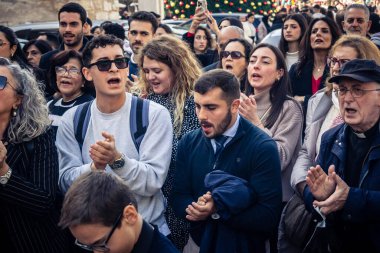 Beytüllahim, Batı Şeria, 25 Aralık 2025. İsa 'ya tapanların yakın çekimleri, İsa' nın Doğumu Kilisesi 'nin önünde rahipler tarafından verilen açık hava konserinde kendilerini adamış bir şekilde şarkı söylemeleri..