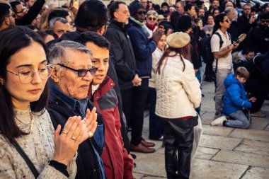 Beytüllahim, Batı Şeria, 25 Aralık 2025. İsa 'ya tapanların yakın çekimleri, İsa' nın Doğumu Kilisesi 'nin önünde rahipler tarafından verilen açık hava konserinde kendilerini adamış bir şekilde şarkı söylemeleri..