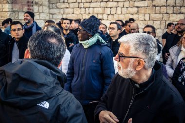 Beytüllahim, Batı Şeria, 25 Aralık 2025 Hristiyan rahipler İsa 'nın Doğumu Kilisesi' nin önünde bir araya gelip din adamları tarafından verilen Noel konseri için alkış ve şarkı söylüyorlar..