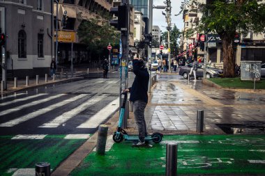 Tel Aviv, İsrail, 29 Aralık 2025. Biri Tel Aviv şehir merkezinde elektrikli scooter kullanıyor. Bu ulaşım şekli buralarda dolaşmanın tercih edilen yollarından biridir..