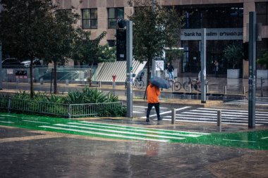 Tel Aviv, İsrail, 29 Aralık 2025. Yayalar şemsiyelerle yağmurda yürür Orta Doğu 'nun en modern şehirlerinden biri olan Tel Aviv sokaklarında..
