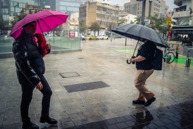 Tel Aviv, İsrail, 29 Aralık 2025. Yayalar şemsiyelerle yağmurda yürür Orta Doğu 'nun en modern şehirlerinden biri olan Tel Aviv sokaklarında..