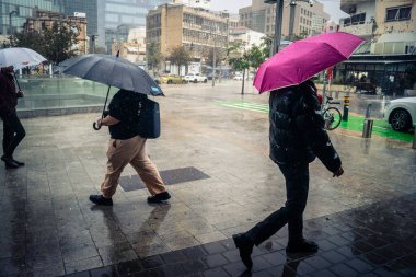 Tel Aviv, İsrail, 29 Aralık 2025. Yayalar şemsiyelerle yağmurda yürür Orta Doğu 'nun en modern şehirlerinden biri olan Tel Aviv sokaklarında..