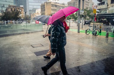 Tel Aviv, İsrail, 29 Aralık 2025. Yayalar şemsiyelerle yağmurda yürür Orta Doğu 'nun en modern şehirlerinden biri olan Tel Aviv sokaklarında..