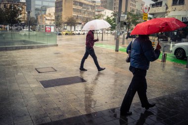 Tel Aviv, İsrail, 29 Aralık 2025. Yayalar şemsiyelerle yağmurda yürür Orta Doğu 'nun en modern şehirlerinden biri olan Tel Aviv sokaklarında..