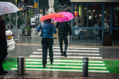 Tel Aviv, İsrail, 29 Aralık 2025. Yayalar şemsiyelerle yağmurda yürür Orta Doğu 'nun en modern şehirlerinden biri olan Tel Aviv sokaklarında..