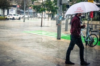 Tel Aviv, İsrail, 29 Aralık 2025. Yayalar şemsiyelerle yağmurda yürür Orta Doğu 'nun en modern şehirlerinden biri olan Tel Aviv sokaklarında..