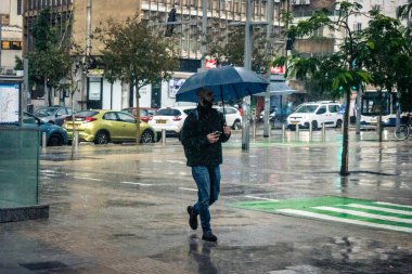 Tel Aviv, İsrail, 29 Aralık 2025. Yayalar şemsiyelerle yağmurda yürür Orta Doğu 'nun en modern şehirlerinden biri olan Tel Aviv sokaklarında..