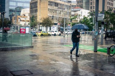 Tel Aviv, İsrail, 29 Aralık 2025. Yayalar şemsiyelerle yağmurda yürür Orta Doğu 'nun en modern şehirlerinden biri olan Tel Aviv sokaklarında..