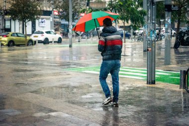 Tel Aviv, İsrail, 29 Aralık 2025. Yayalar şemsiyelerle yağmurda yürür Orta Doğu 'nun en modern şehirlerinden biri olan Tel Aviv sokaklarında..