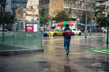 Tel Aviv, İsrail, 29 Aralık 2025. Yayalar şemsiyelerle yağmurda yürür Orta Doğu 'nun en modern şehirlerinden biri olan Tel Aviv sokaklarında..