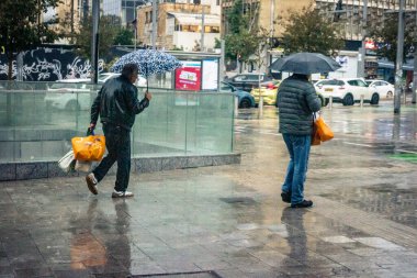 Tel Aviv, İsrail, 29 Aralık 2025. Yayalar şemsiyelerle yağmurda yürür Orta Doğu 'nun en modern şehirlerinden biri olan Tel Aviv sokaklarında..