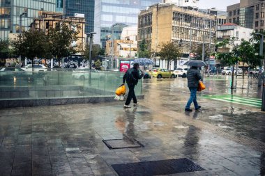 Tel Aviv, İsrail, 29 Aralık 2025. Yayalar şemsiyelerle yağmurda yürür Orta Doğu 'nun en modern şehirlerinden biri olan Tel Aviv sokaklarında..