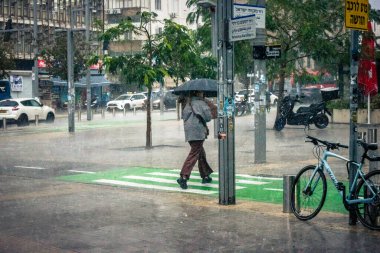 Tel Aviv, İsrail, 29 Aralık 2025. Yayalar şemsiyelerle yağmurda yürür Orta Doğu 'nun en modern şehirlerinden biri olan Tel Aviv sokaklarında..