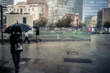 Tel Aviv, İsrail, 29 Aralık 2025. Yayalar şemsiyelerle yağmurda yürür Orta Doğu 'nun en modern şehirlerinden biri olan Tel Aviv sokaklarında..