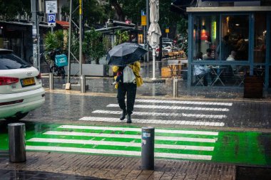 Tel Aviv, İsrail, 29 Aralık 2025. Yayalar şemsiyelerle yağmurda yürür Orta Doğu 'nun en modern şehirlerinden biri olan Tel Aviv sokaklarında..
