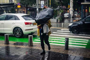Tel Aviv, İsrail, 29 Aralık 2025. Yayalar şemsiyelerle yağmurda yürür Orta Doğu 'nun en modern şehirlerinden biri olan Tel Aviv sokaklarında..