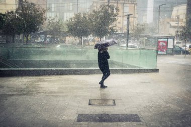 Tel Aviv, İsrail, 29 Aralık 2025. Yayalar şemsiyelerle yağmurda yürür Orta Doğu 'nun en modern şehirlerinden biri olan Tel Aviv sokaklarında..